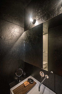 Hangkast in badkamer in zwart gelakte OSB met opstaande lavabo