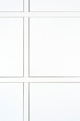 Wandkast in leefruimte met strak lijnenspel van deurtjes in wit gelakte MDF