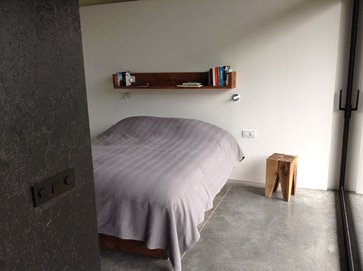 Slaapkamer met bed en wandkast in steigerhout